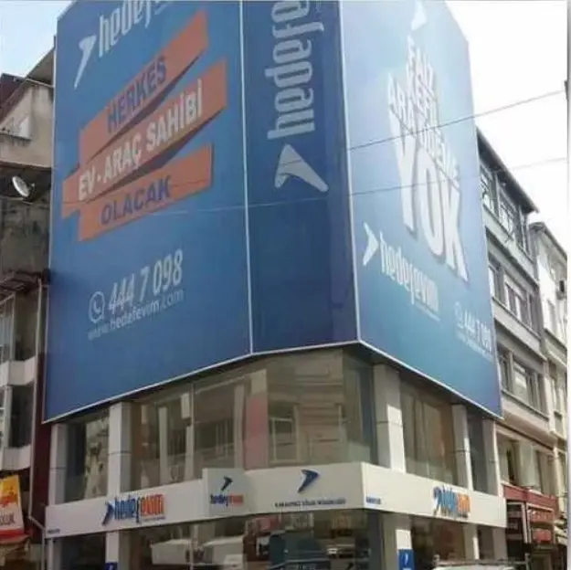 Köşe binanın iki cephesini kaplayan büyük mavi baskılı vinil branda